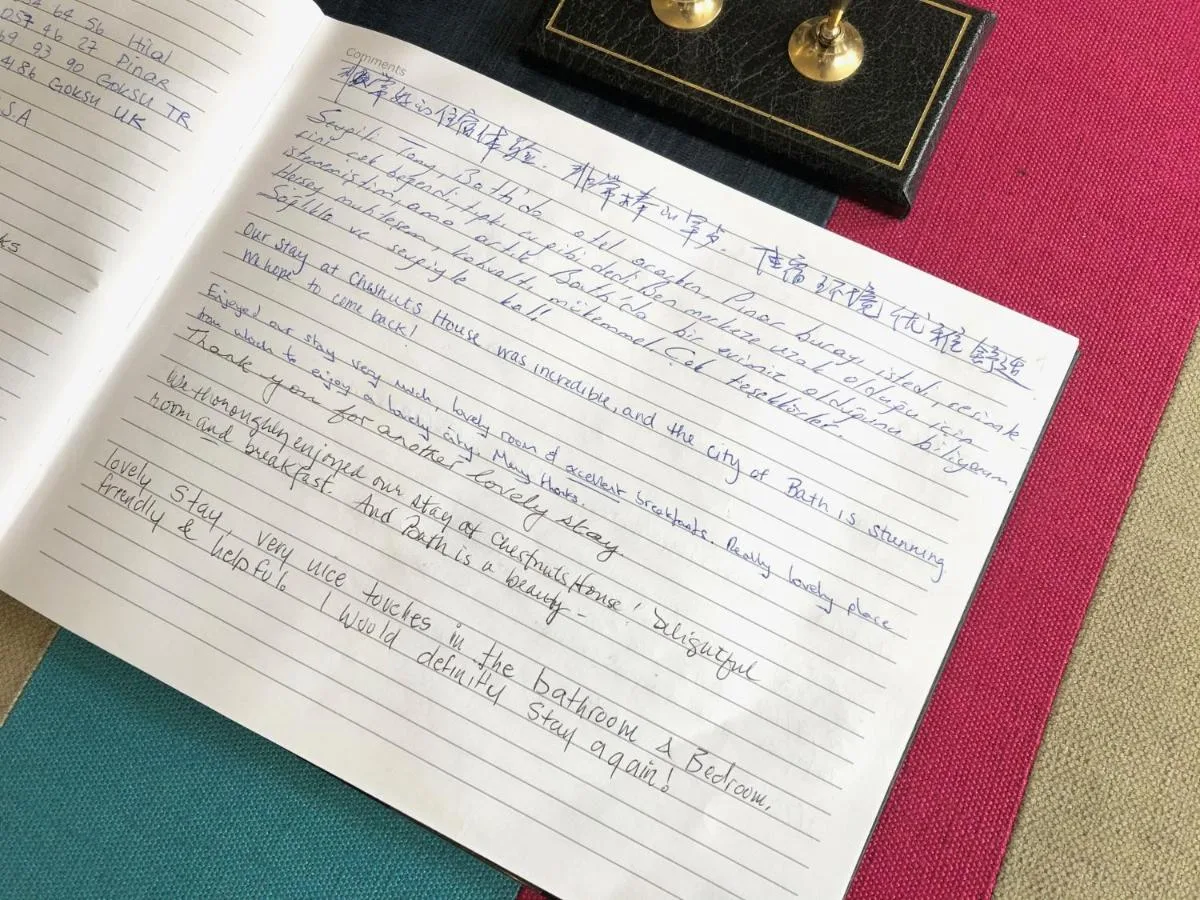 a book with handwriting on it on a table at Chestnuts House Boutique B&B in Bath