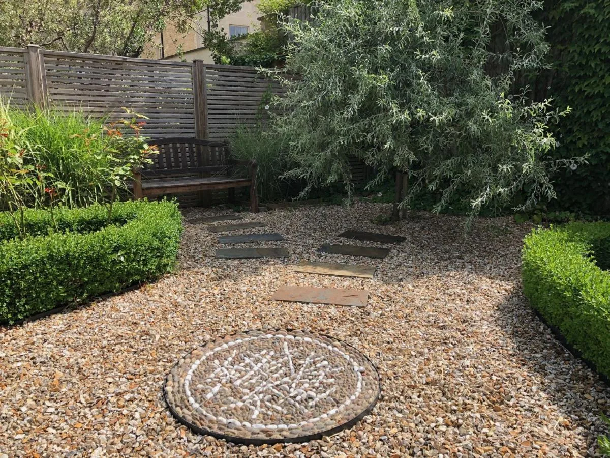 a garden with a manhole cover and a bench at Chestnuts House Boutique B&B in Bath