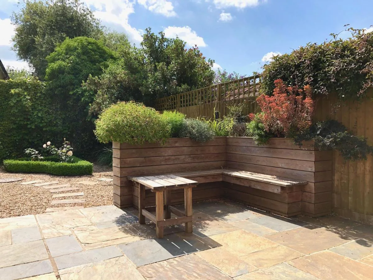 a wooden bench sitting in the middle of a garden at Chestnuts House Boutique B&B in Bath